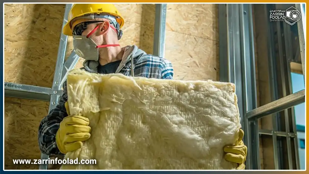 اپراتور با رعایت تمام نکات ایمنی در حال حمل پشم شیشه است.