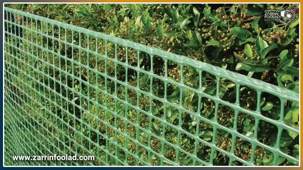 توری مرغی پلاستیکی سبز رنگ که به عنوان حصار دور باع نصب شده است