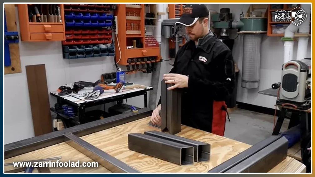 یک مرد در حال مونتاژ پروفیلهای آهن برای ساخت میز