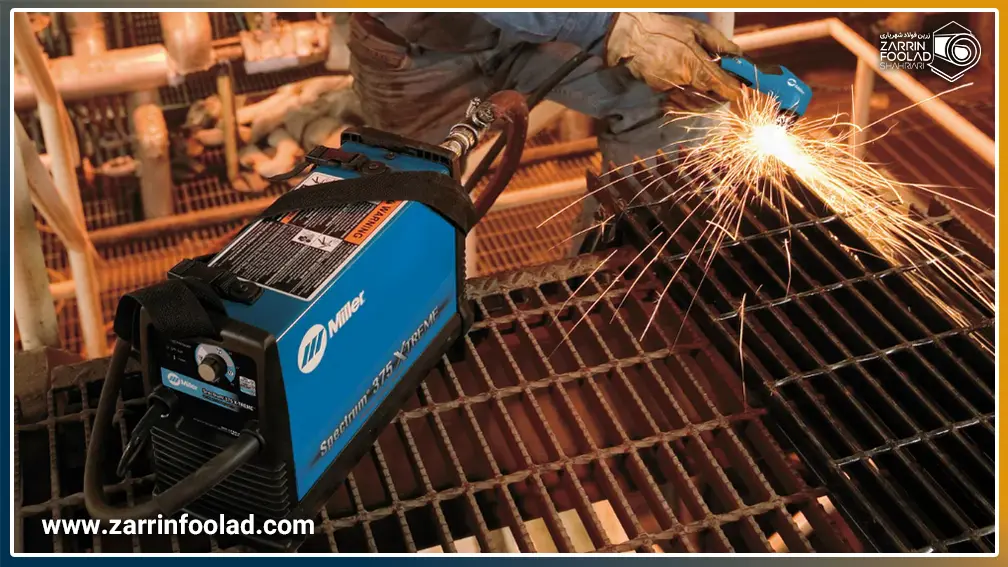 اپراتور در حال برش پلاسما یک قطعه فلزی است.