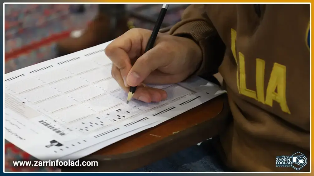 دست داوطلب آزمون فولاد آرند در حال پر کردن پاسخنامه